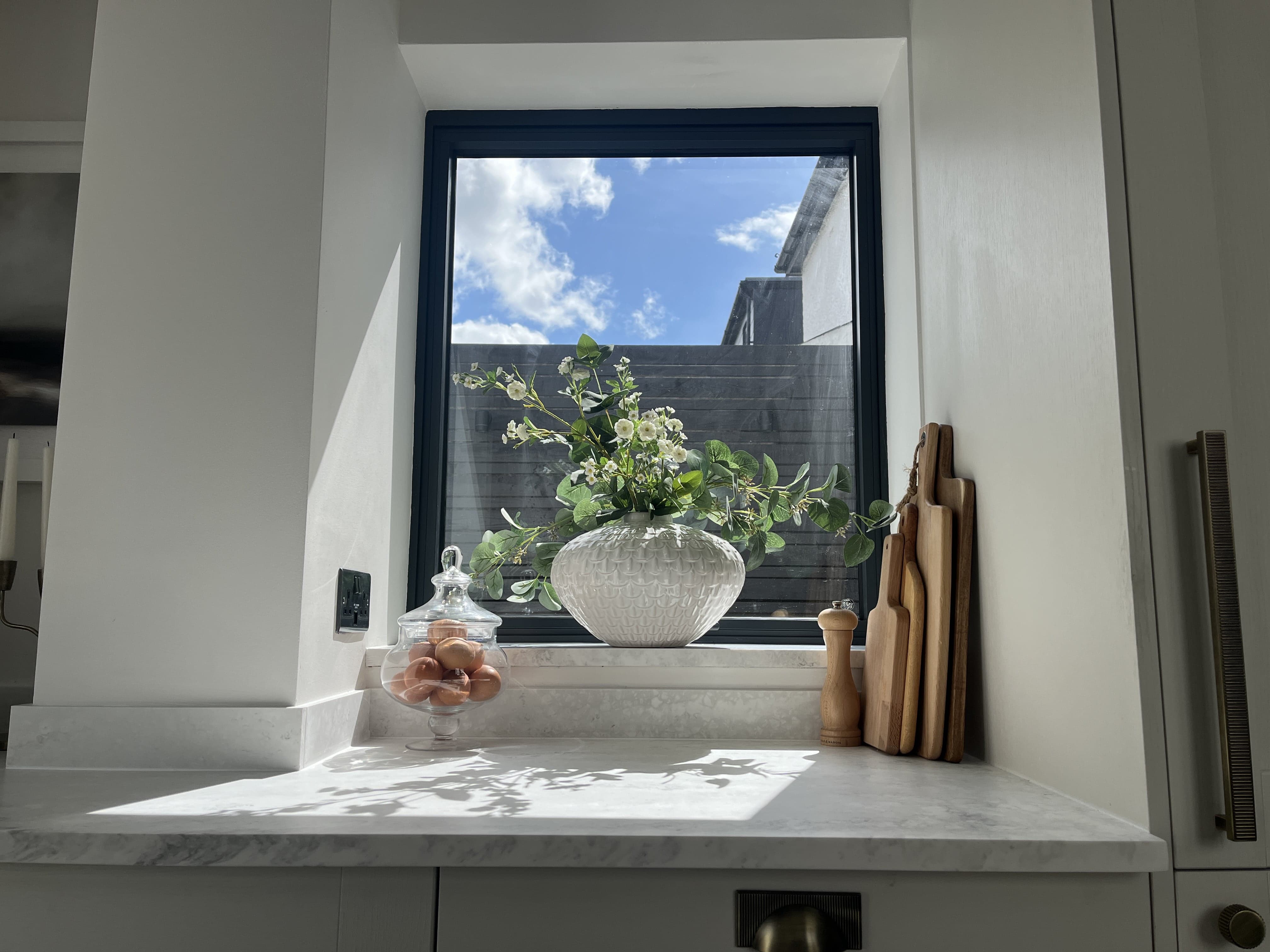 Dark aluminium framed window in a marble kitchen